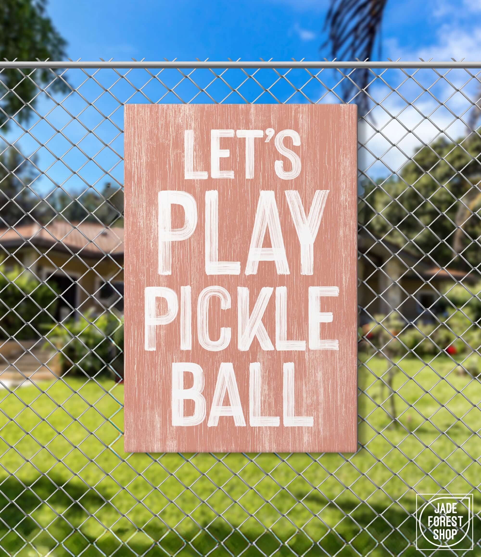 a sign on a fence that says let's play pickle ball