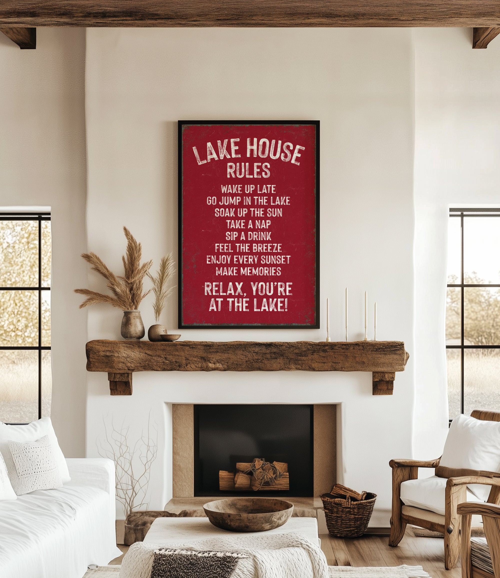 a cozy living room with a fireplace, a wooden mantel, and a framed sign that reads "Lake House Rules" in bold white letters. The sign lists various rules for guests to follow, such as "Wake up late", "Go jump in the lake", "Take a nap", "Sip the sun", "Feel the breeze", "Enjoy every moment", and "Relax, you're at the lake!" The room also includes a couch, a chair, and a potted plant, creating a warm and inviting atmosphere.