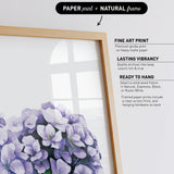 a framed print of a bouquet of purple flowers, with a natural frame.