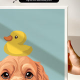 a person holding a framed print of a cartoon image depicting a duck sitting on a dog's head.