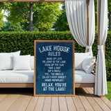 A sign on a wooden deck with a scenic view of a lake, featuring a list of rules for visitors to follow while relaxing at the lake house.