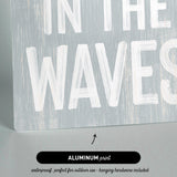 a wooden sign that says in the waves