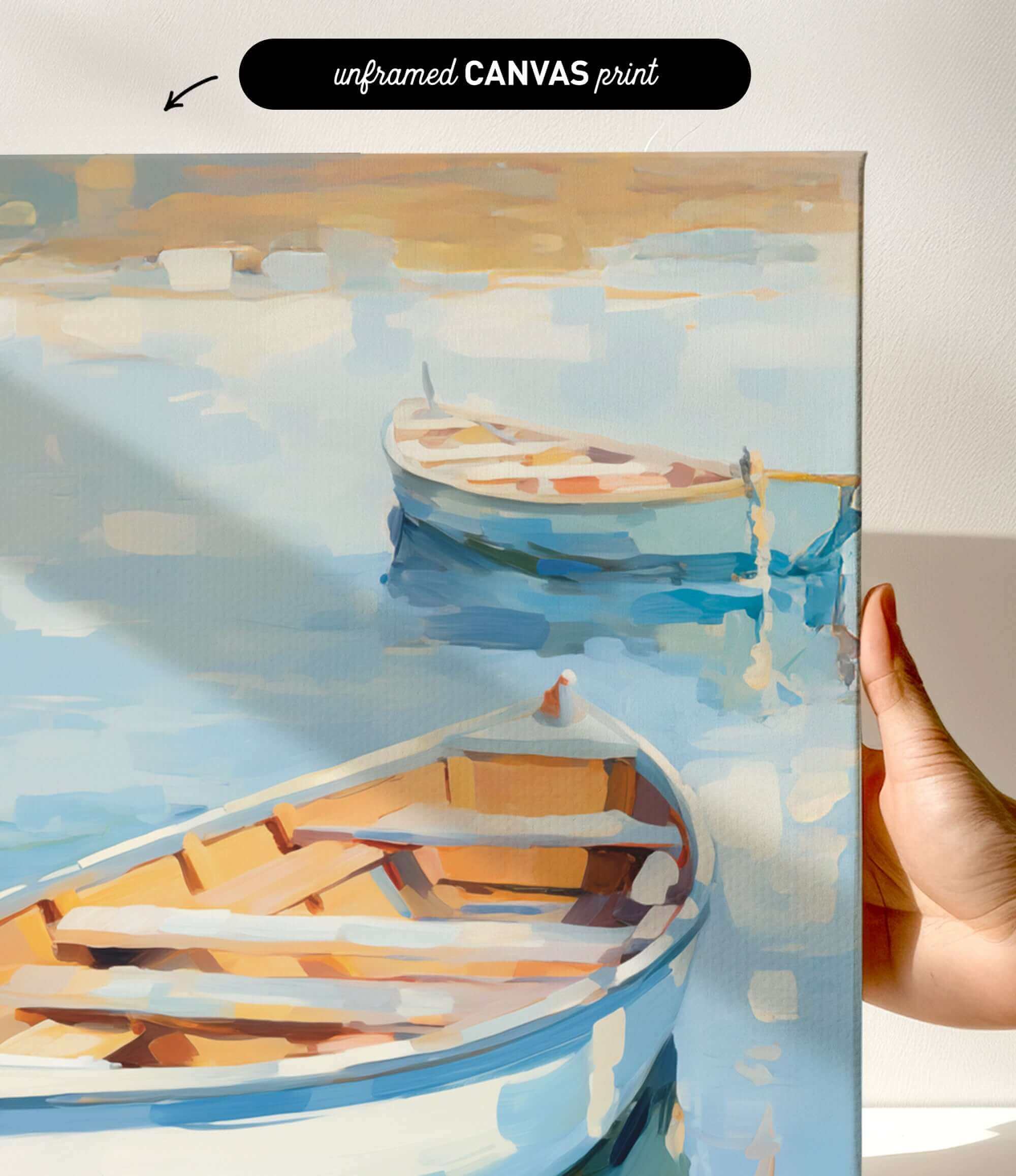 a hand holding a framed painting of two boats on a body of water.