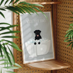 A framed poster with a black dog sitting in a bathtub filled with bubbles, surrounded by green leaves.