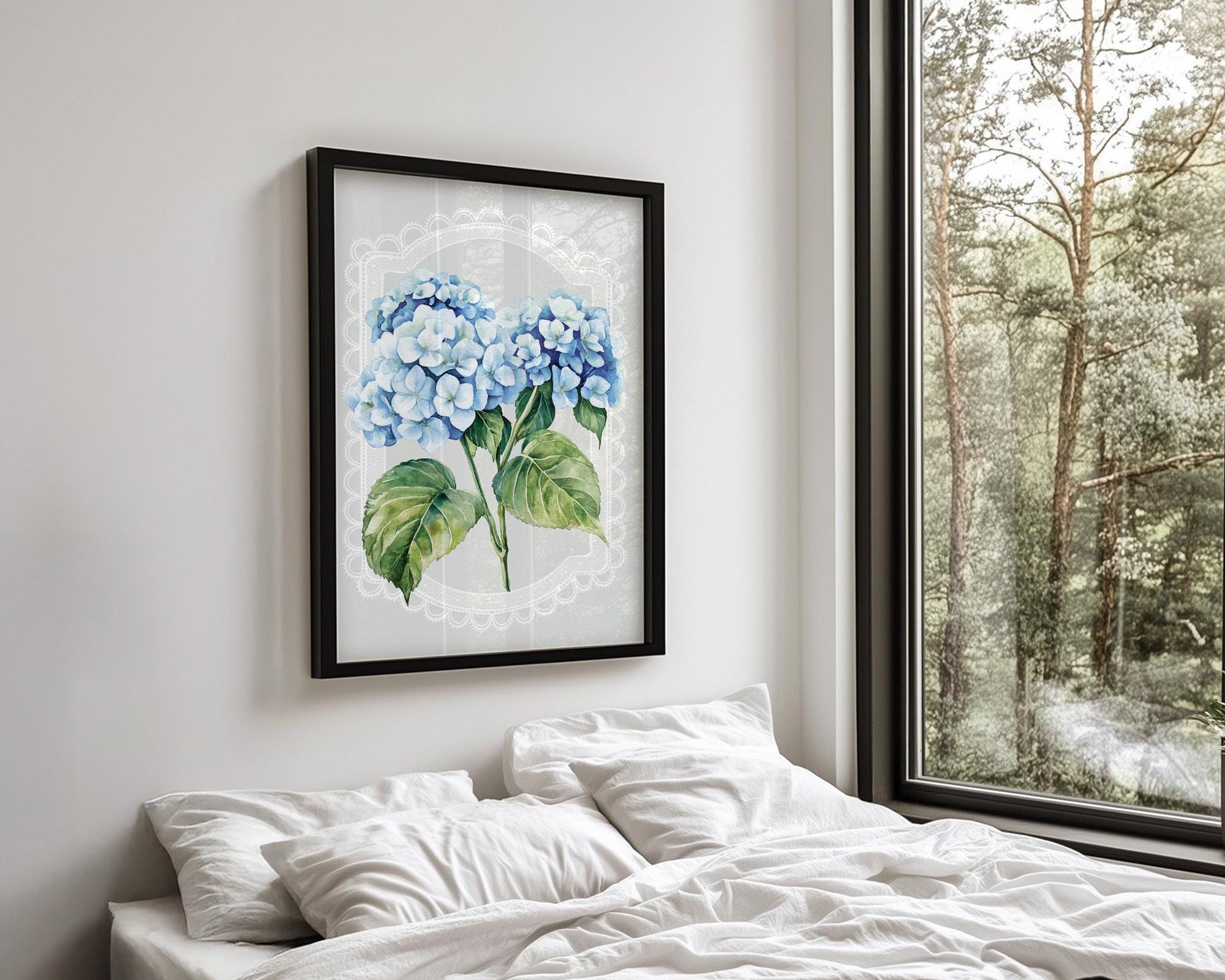 a serene bedroom scene with a large window overlooking a lush green forest. The focal point is a framed painting of blue hydrangeas hanging on the wall above a bed with white pillows and a black blanket.