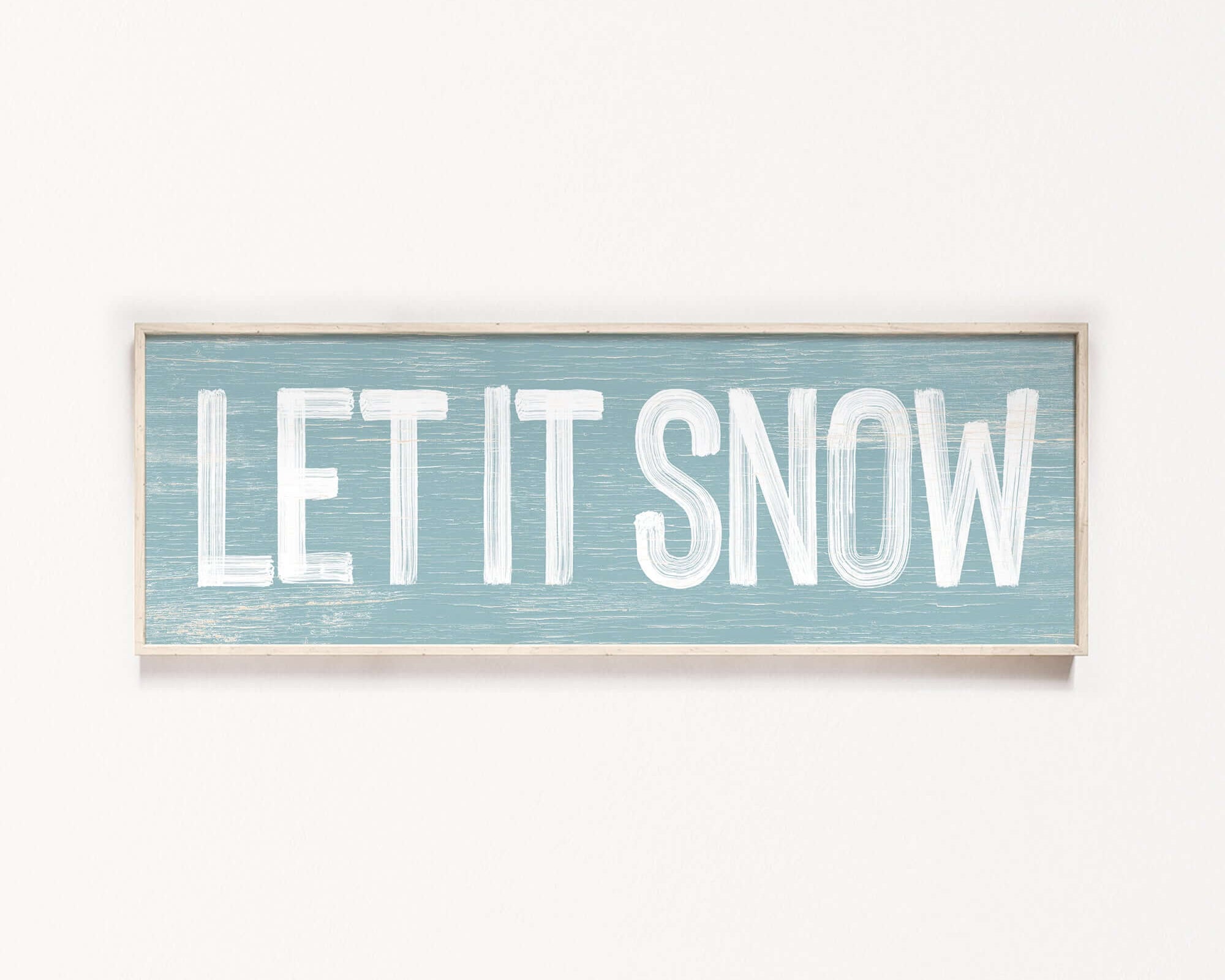 a sign that says let it snow hanging on a wall