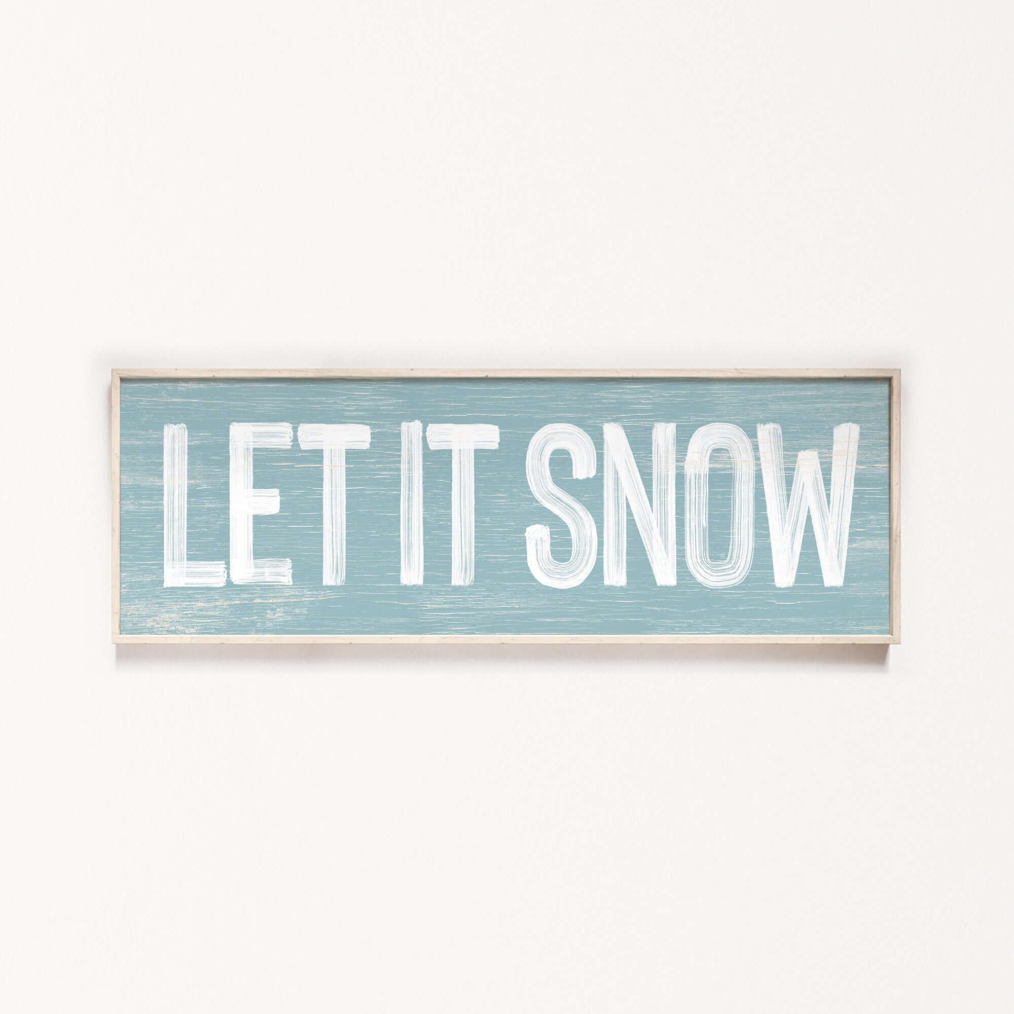 a sign that says let it snow hanging on a wall