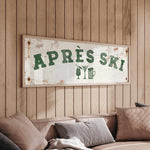 a wooden wall with a framed sign that reads "APRÈS SKI", accompanied by a beer mug and a wine glass icon.