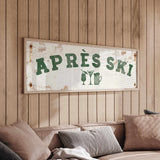 a wooden wall with a framed sign that reads "APRÈS SKI", accompanied by a beer mug and a wine glass icon.