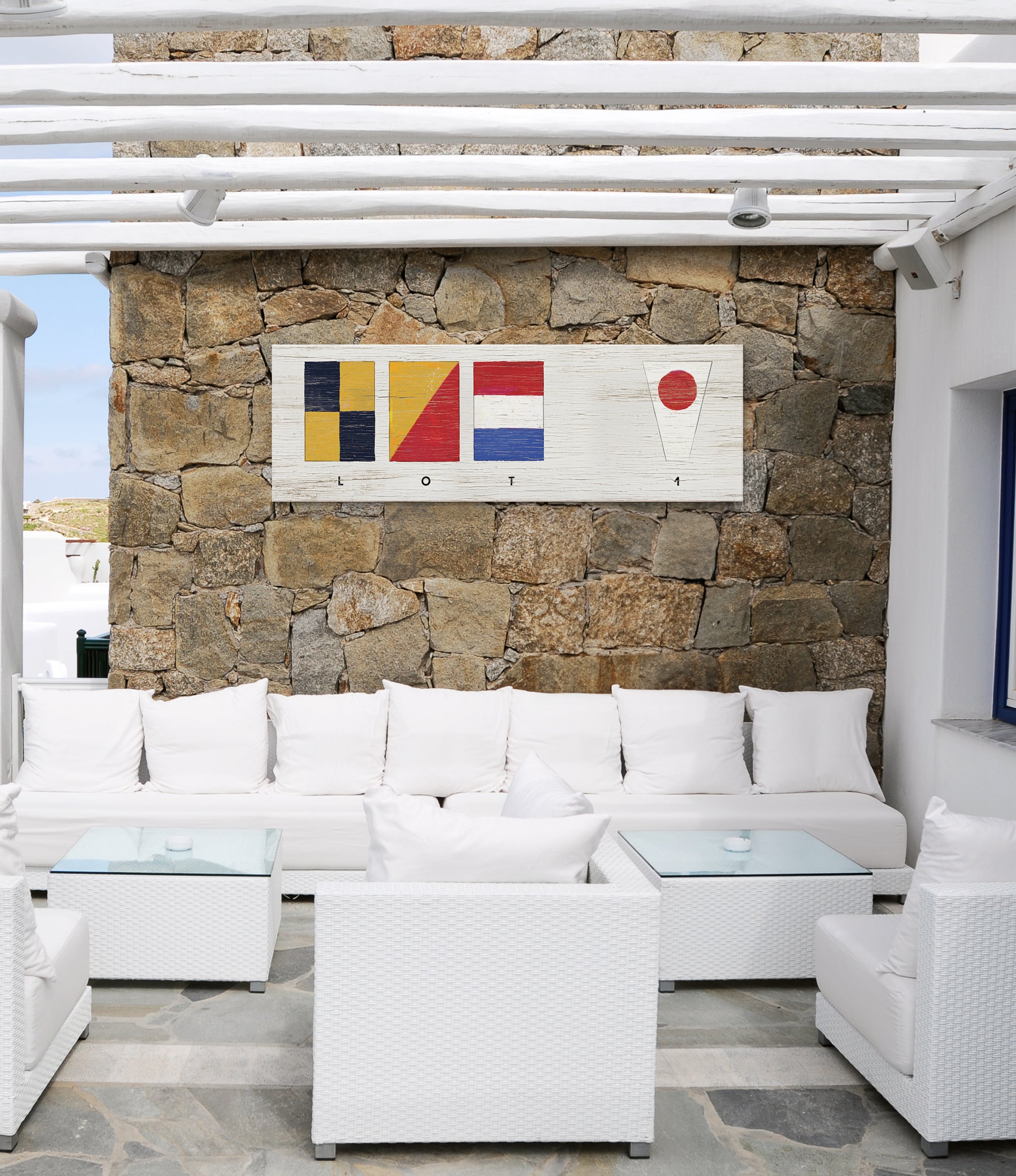 a living room with white furniture and a stone wall