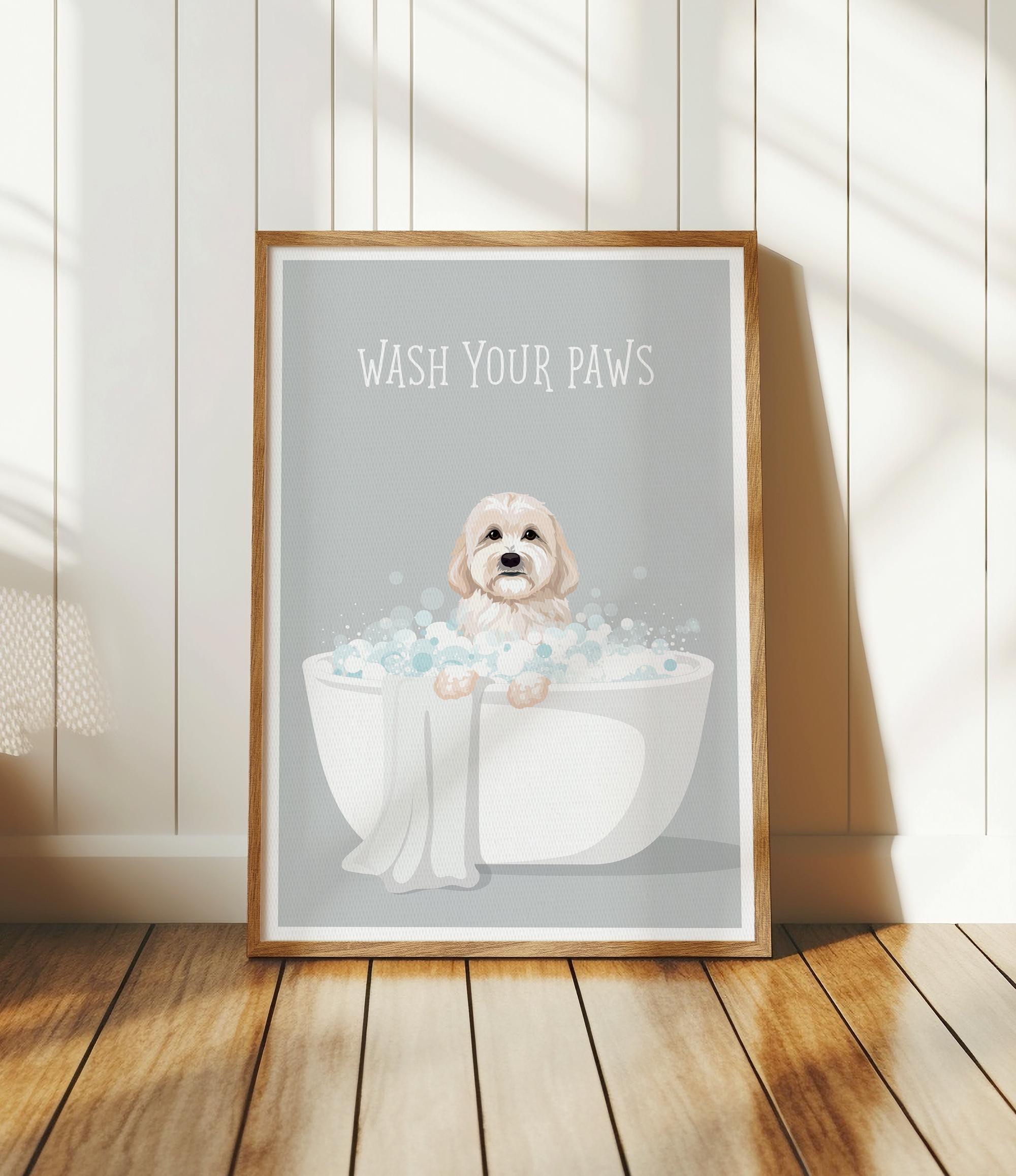 A framed poster with a cute dog sitting in a bathtub filled with bubbles, accompanied by the text "WASH YOUR PAWS".