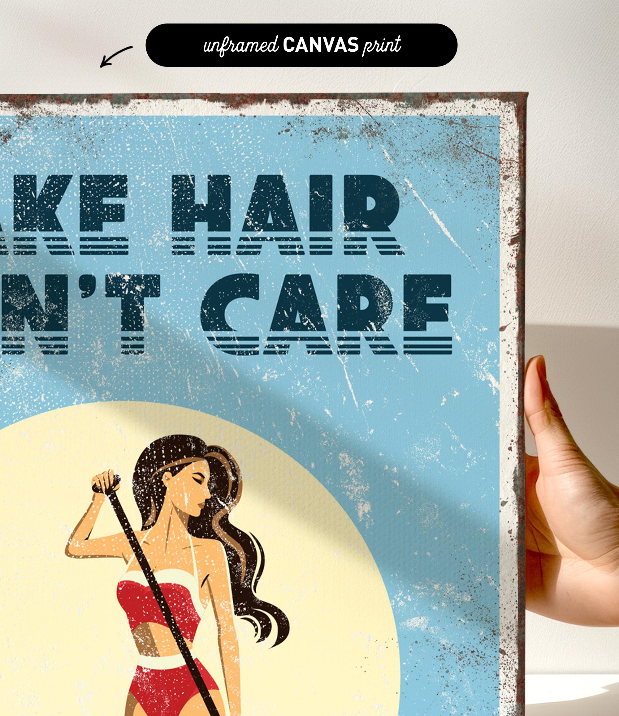 The image is a hand holding a framed print with a vintage-style illustration of a woman with long hair. The text on the print reads "Make hair care" and is in a bold, stylized font.