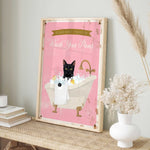 A framed poster with a black cat sitting in a bathtub filled with bubbles, accompanied by a pink background and a banner that reads "Please don't forget to wash your pans".