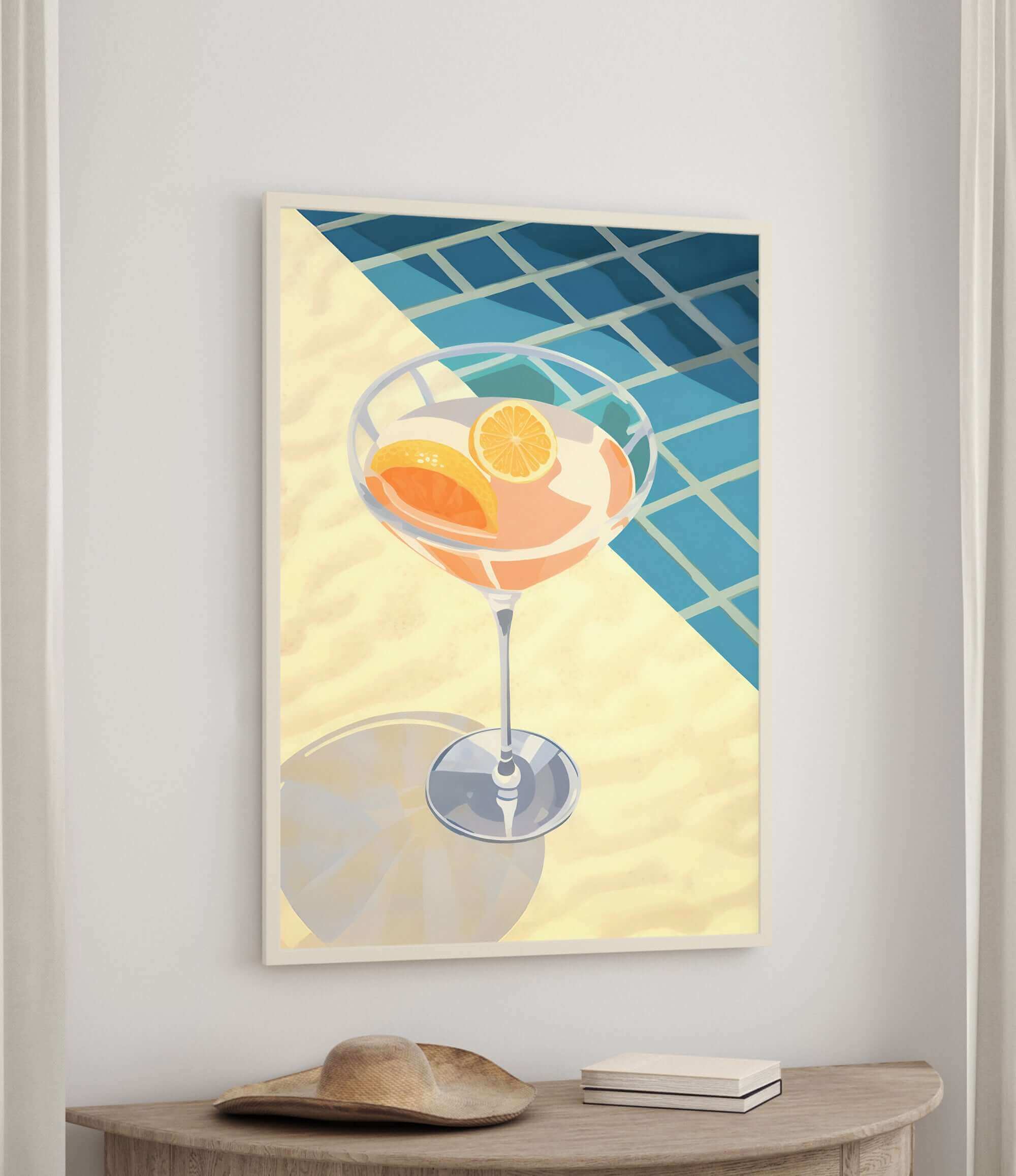 a framed illustration of a cocktail glass filled with orange slices, placed on a wooden table.