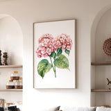 a framed painting of pink hydrangeas hanging on a wall in a living room.