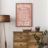 The Beach House Rules Sign, Painted Wood, Coral, adds charm as beach house wall decor when displayed above a wooden dresser next to a lamp and a basket of flowers.