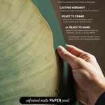 a hand holding a piece of paper with text and a leaf-like design on it.