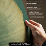 a hand holding a piece of paper with text and a leaf-like design on it.