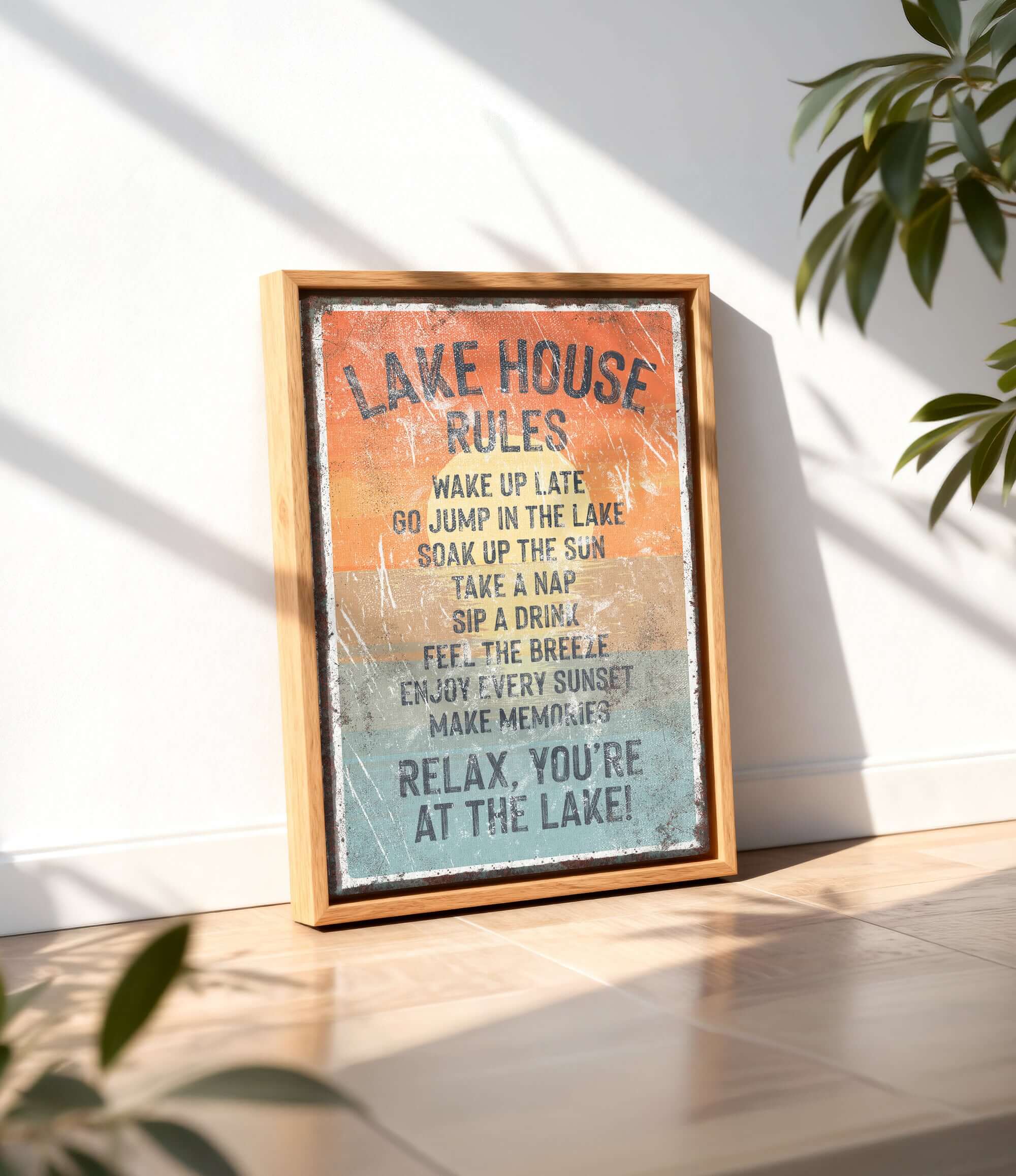 A framed sign with the text "LAKESHOUSE RULES" is displayed on a wooden floor, with a plant in the background.