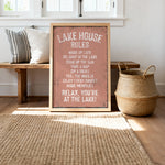 A framed sign with a list of rules for the Lake House, placed on a wooden bench and a woven basket, with a window and a rug in the background.
