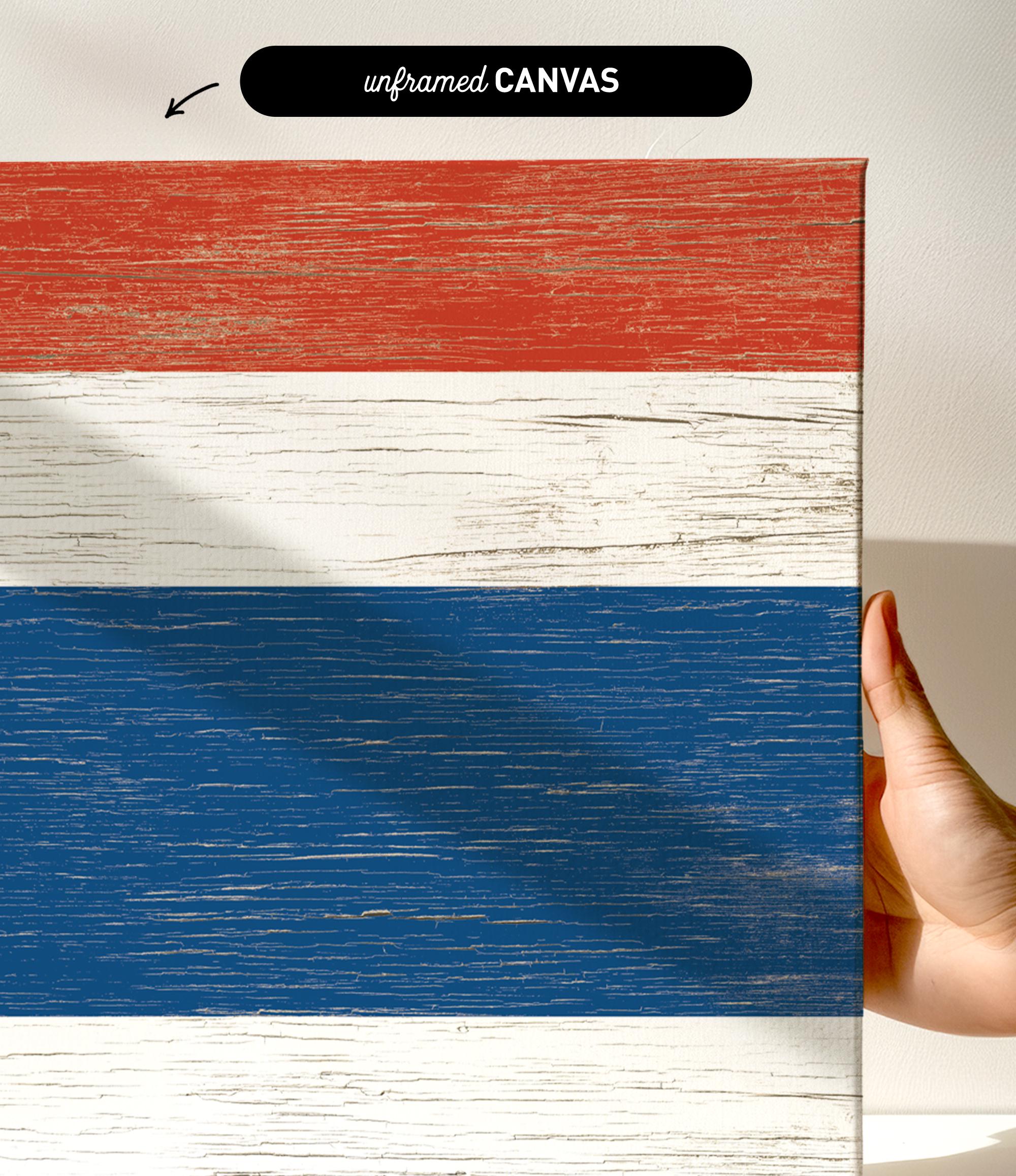 a hand holding a piece of wood with a flag painted on it
