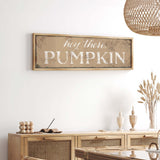 a white wall with a wooden sign that says hey there pumpkin