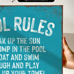 a hand holding a sign that says pool rules