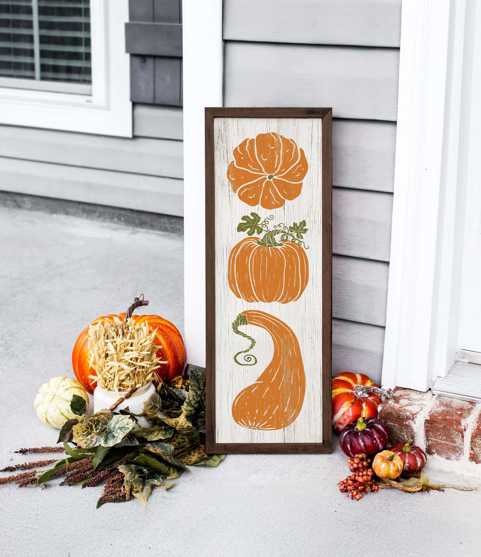 a picture of pumpkins and gourds on a porch