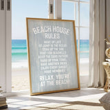 a framed sign with beach-themed rules, placed in a room with a view of the ocean through a window.