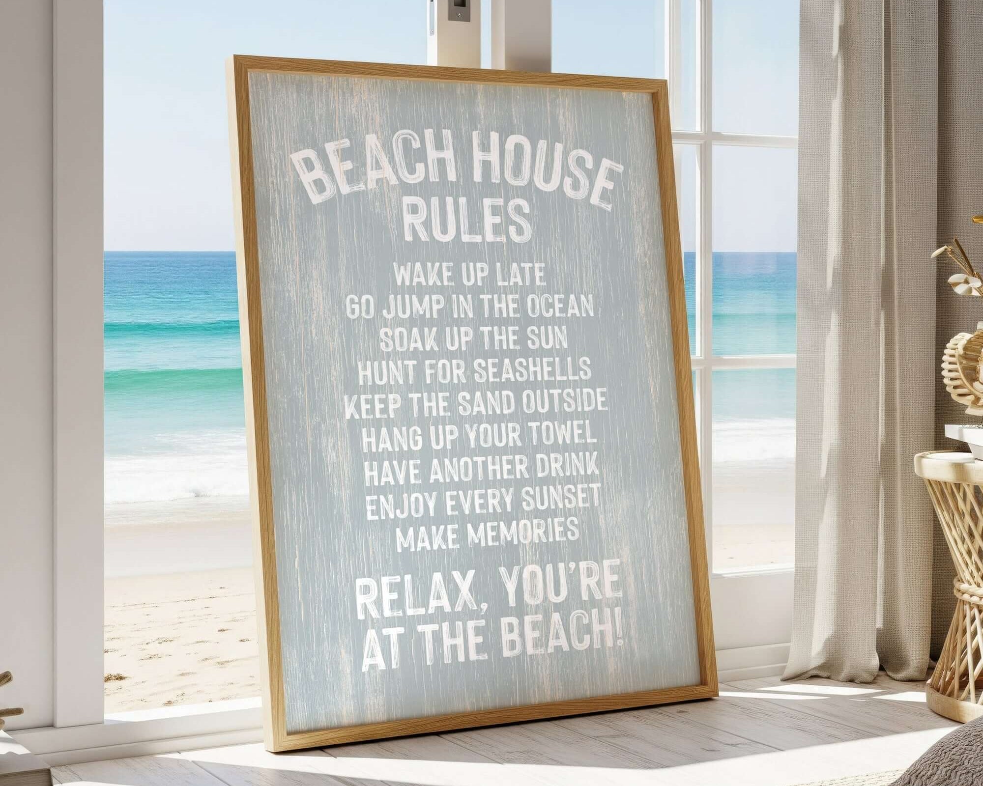 a framed sign with beach-themed rules, placed in a room with a view of the ocean through a window.