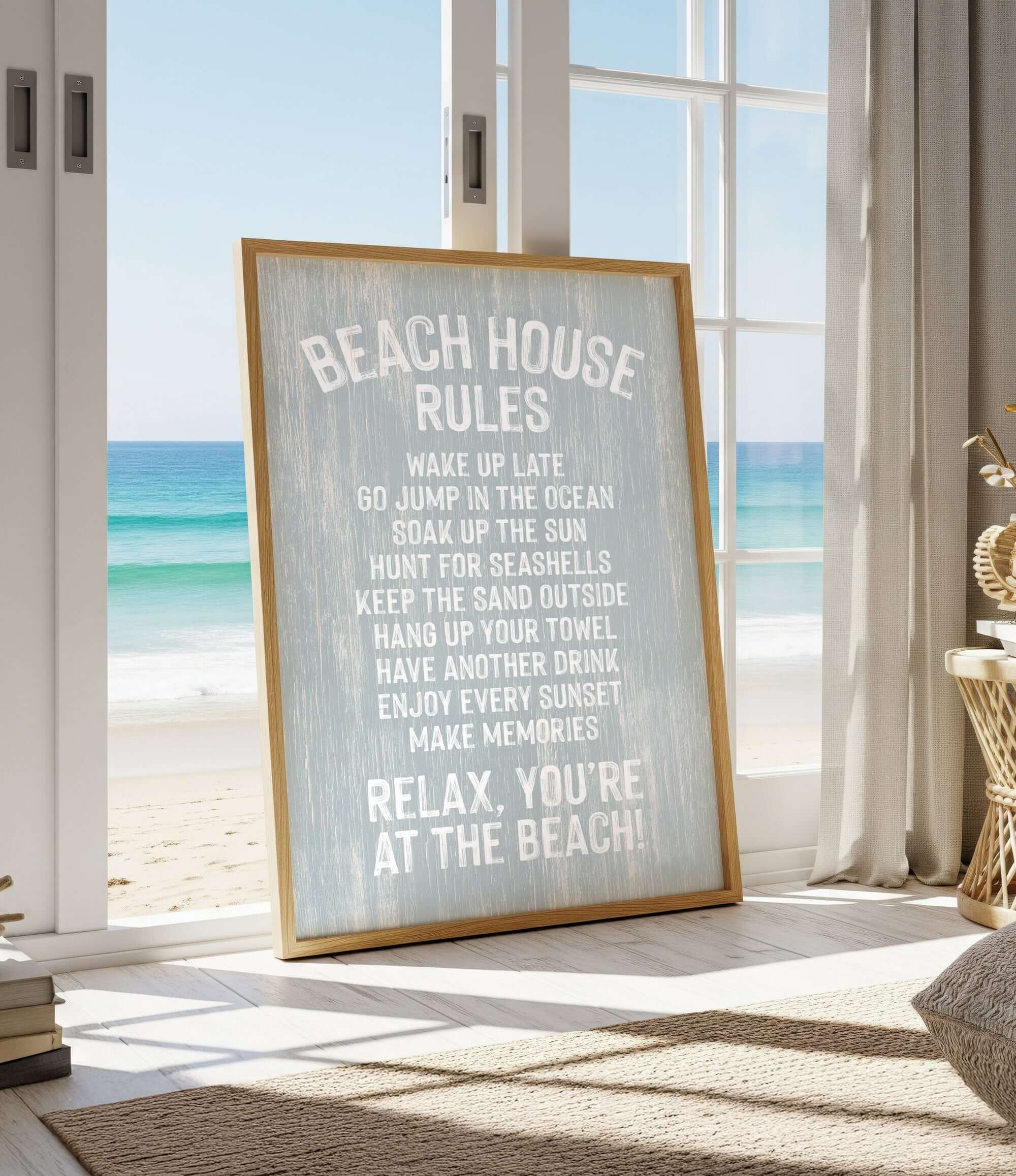 a framed sign with beach-themed rules, placed in a room with a view of the ocean through a window.
