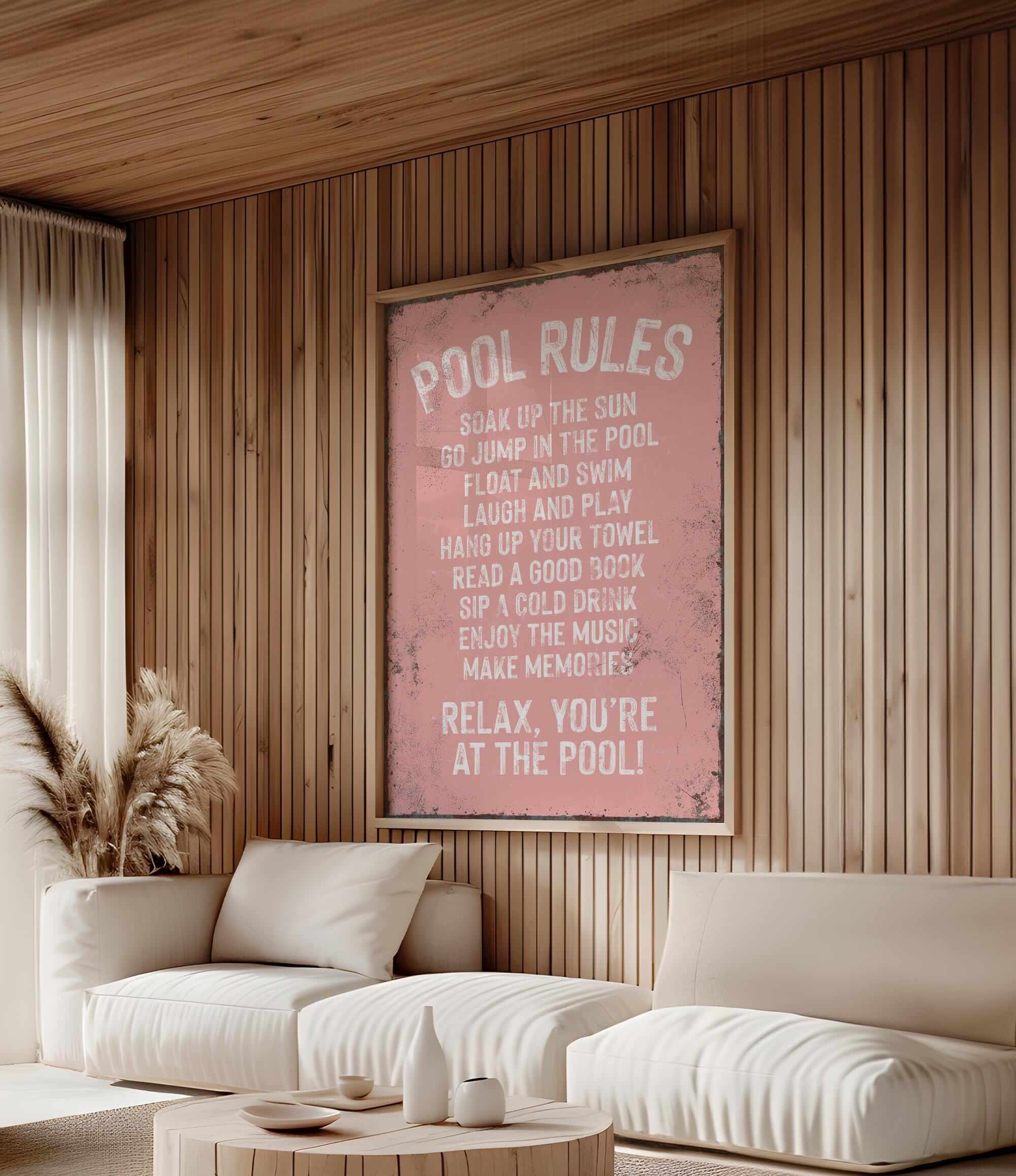 a living room with a white couch and a pink poster