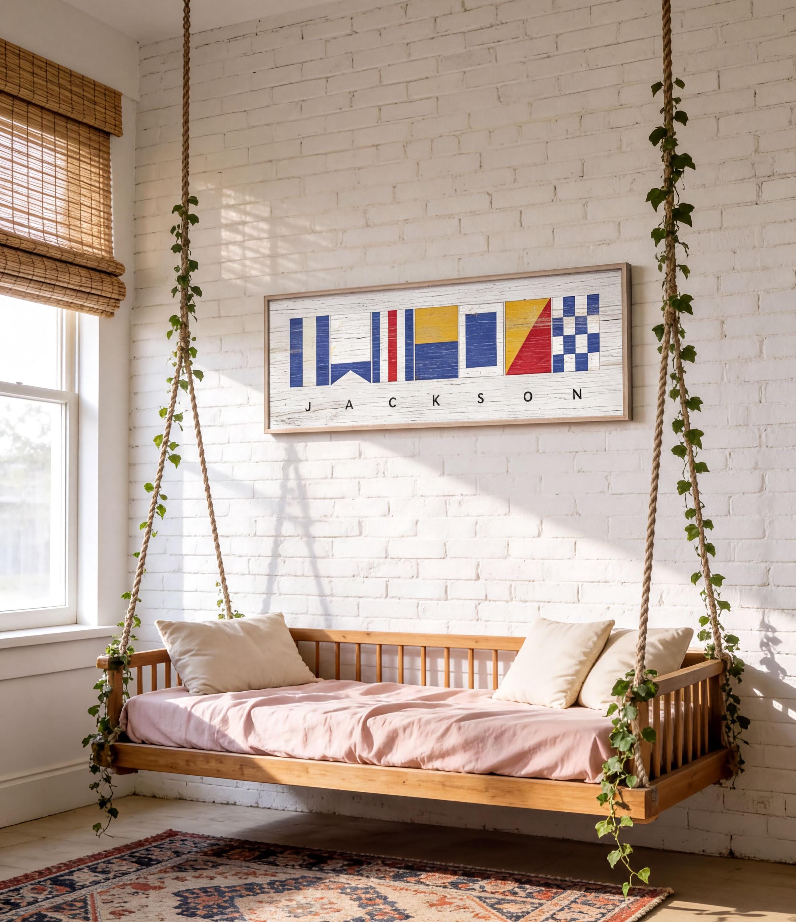 a cozy bedroom with a wooden bed suspended from the ceiling by ropes, creating a unique and comfortable sleeping space. The bed is adorned with white pillows and a pink blanket, adding a touch of warmth and comfort to the room. Above the bed, there is a framed artwork depicting nautical flags, adding a nautical theme to the space. The room is also decorated with potted plants, which contribute to the overall pleasant and inviting atmosphere.
