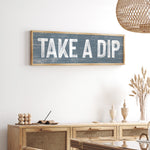 a wooden sign that says take a dip