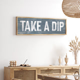 a wooden sign that says take a dip