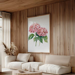 a cozy living room with a large floral painting hanging on the wall, featuring a vibrant pink hydrangea flower. The room is furnished with a sofa and a coffee table, creating a comfortable and inviting atmosphere.