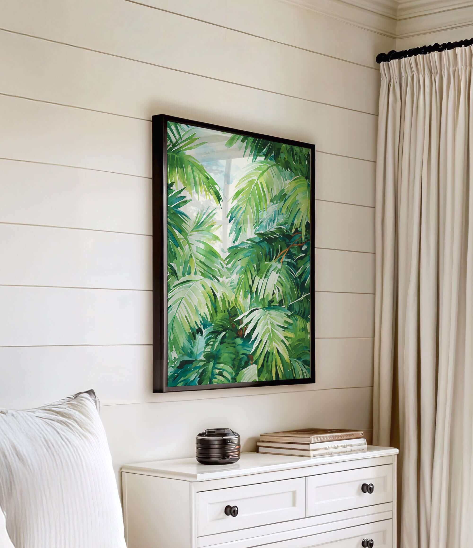 a white dresser with a framed painting of lush green palm leaves hanging on the wall above it.