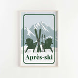 A framed print featuring a pair of green Adirondack chairs with skis and ski poles, set against a snowy mountain backdrop.