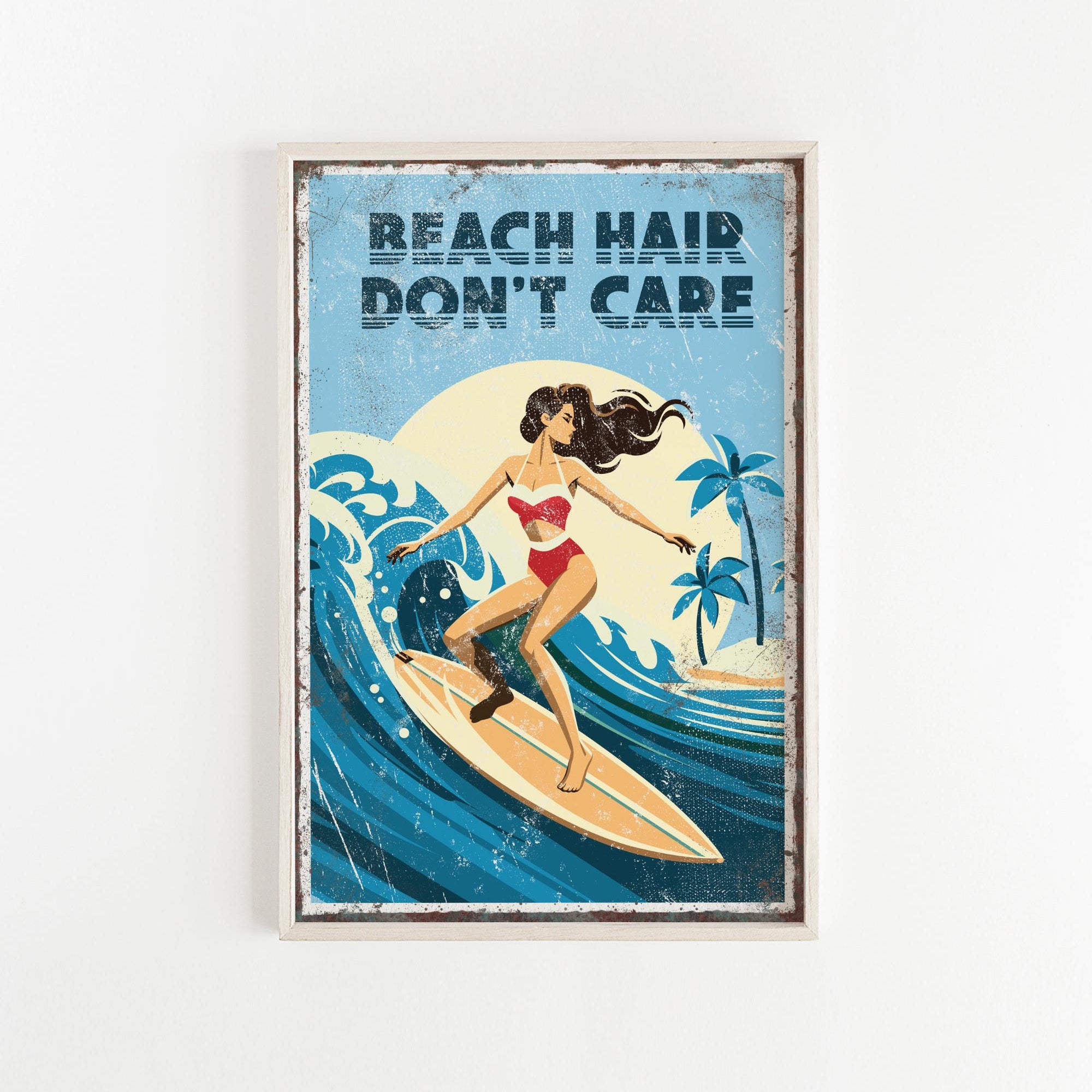 A framed poster with a woman surfing on a wave, with the text "REACH HAIR DON'T CARE" written above the image.