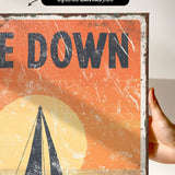 a hand holding up a poster with a sailboat on it