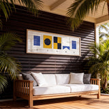 a wooden deck with a white sofa and a framed artwork hanging on the wall above it.