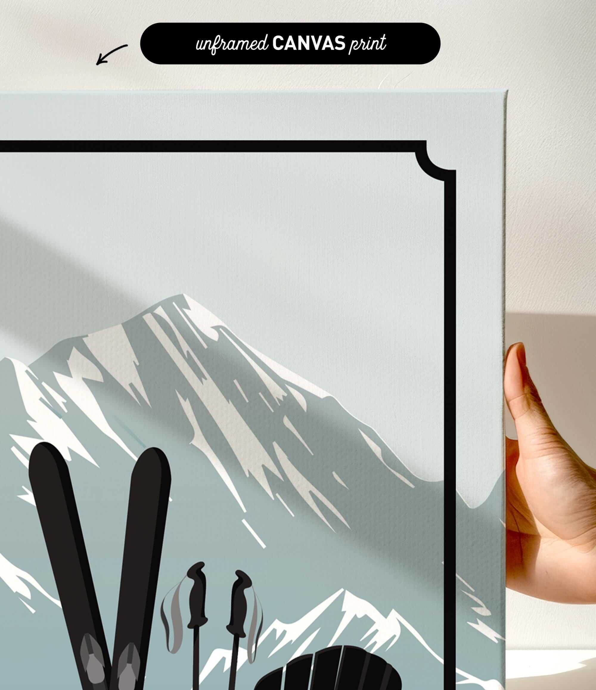 a hand holding a framed print of a mountain landscape with skis and ski poles, indicating a skiing theme.