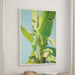 a large, vibrant painting of a banana tree hanging on a wall.