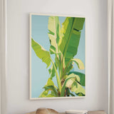 a large, vibrant painting of a banana tree hanging on a wall.