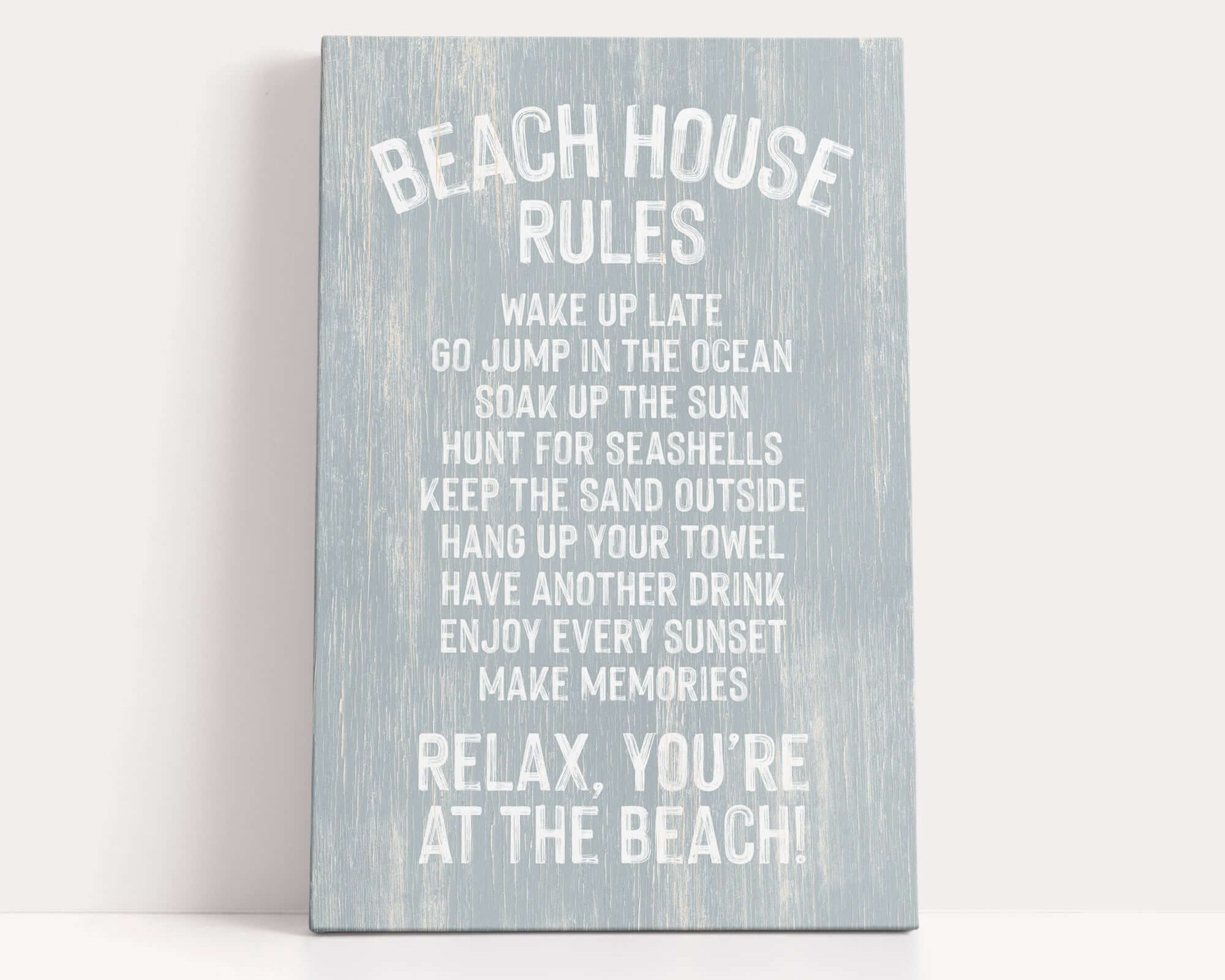a sign with a list of beach house rules written in white text on a light blue background.