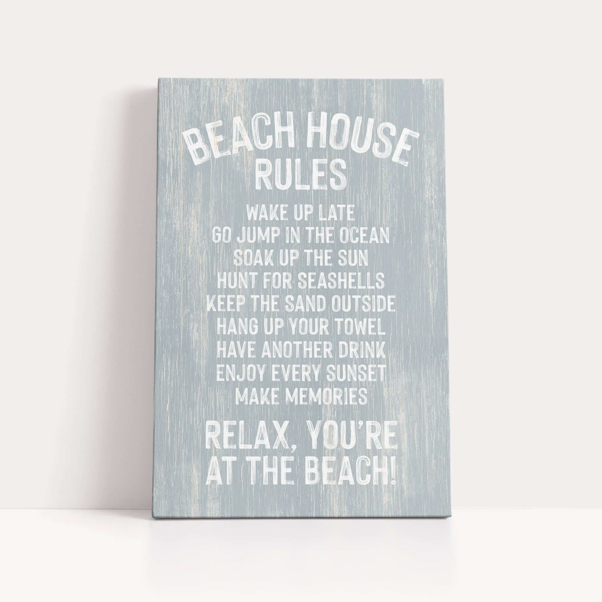 a sign with a list of beach house rules written in white text on a light blue background.