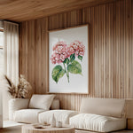 a cozy living room with a large floral painting hanging on the wall, featuring two pink hydrangeas with green leaves. The room is furnished with a sofa, a coffee table, and a potted plant, creating a warm and inviting atmosphere.