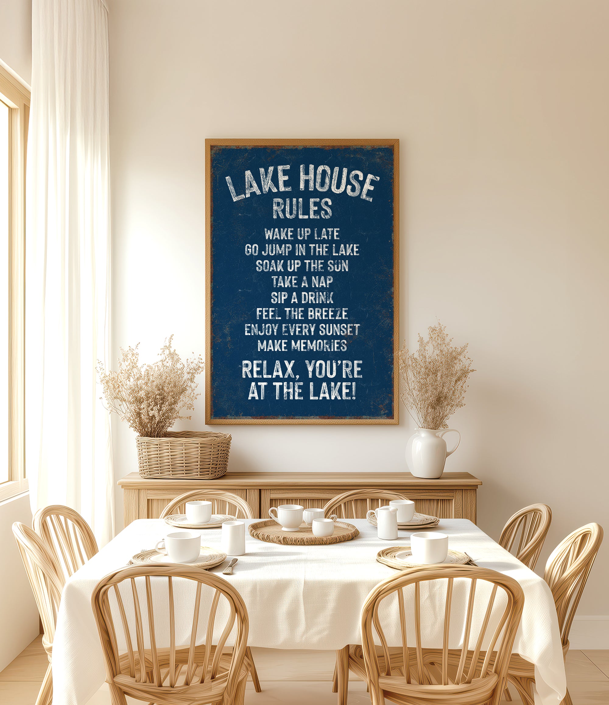 a dining room with a table set for a meal, surrounded by wooden chairs. Above the table, there is a framed sign with the text "LAKESHOUSE RULES" written on it.