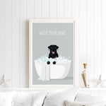 A framed poster with a black dog sitting in a white bathtub filled with bubbles, with the text "WASH YOUR PAWS" displayed above it.