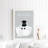 A framed poster with a black dog sitting in a white bathtub filled with bubbles, with the text "WASH YOUR PAWS" displayed above it.